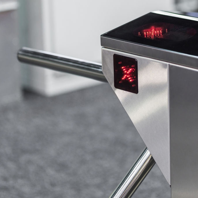 Closed entrance turnstile with access denied red sign. Security barrier.